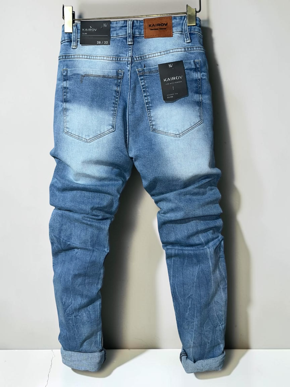 Pantalones de mezclilla Mi tienda KAIROV corte slim en azul claro con acabado deslavado y etiqueta de cuero trasera