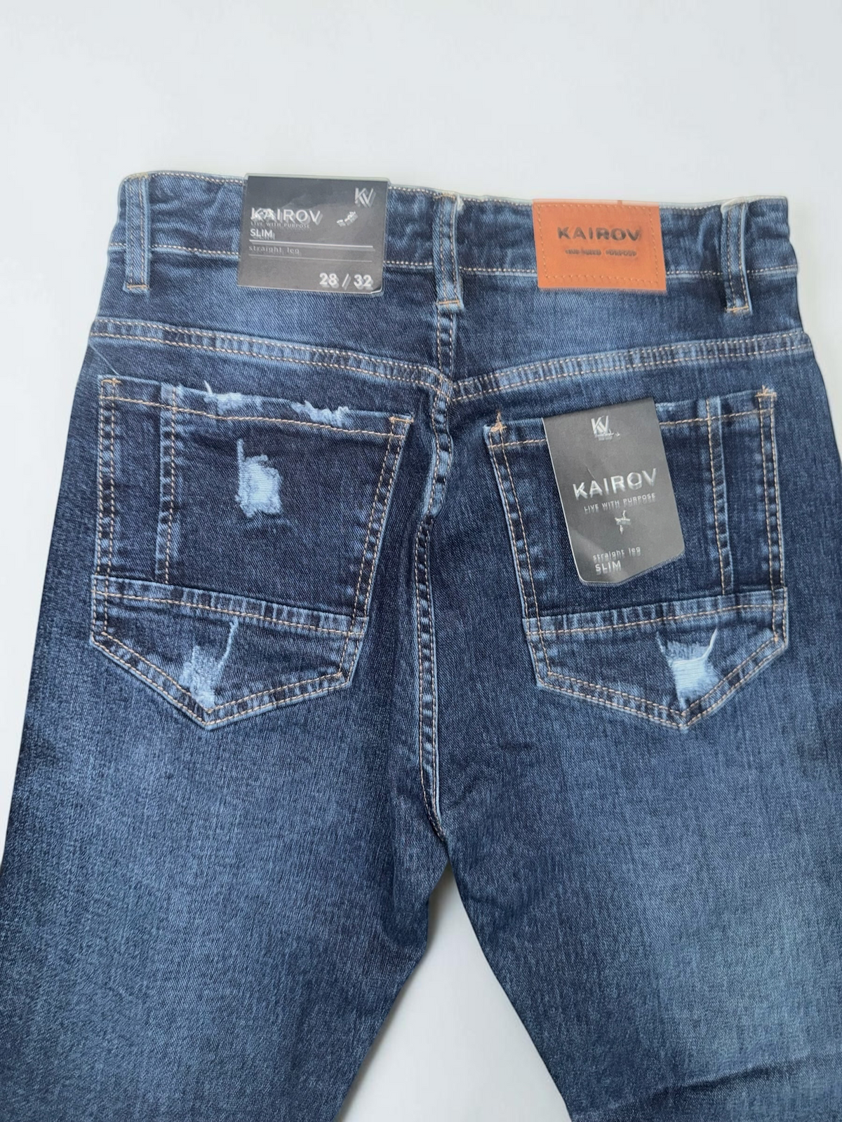Jeans Mi tienda KAIROV slim fit en azul oscuro con detalles desgastados y roturas en los bolsillos traseros
