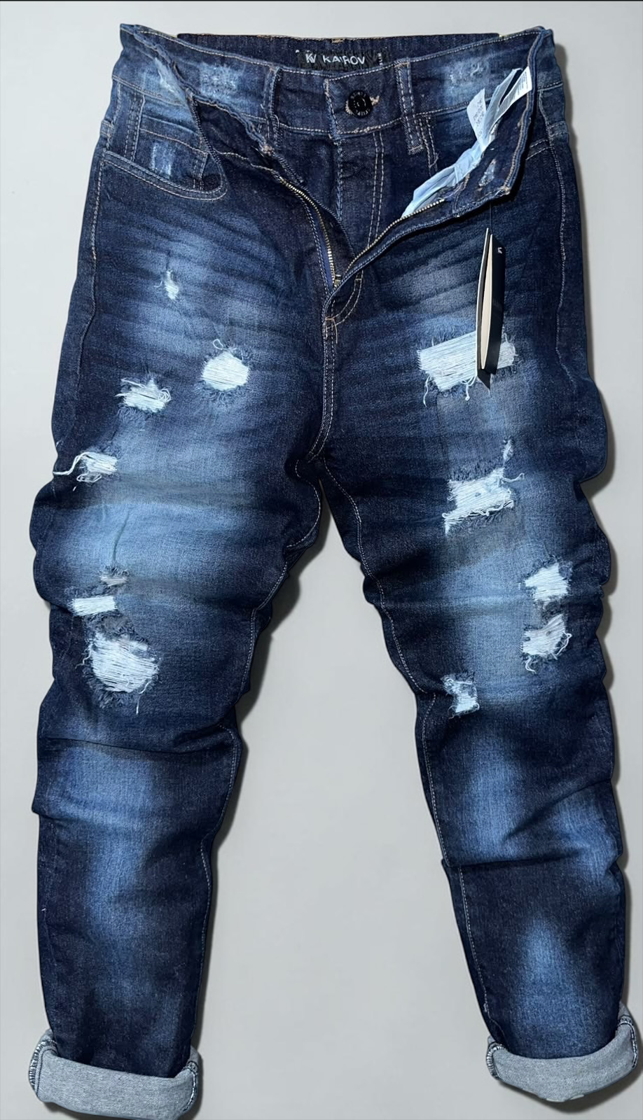 Jeans Mi tienda KAIROV de mezclilla azul oscuro con corte slim, efecto deslavado y detalles desgastados para hombre.