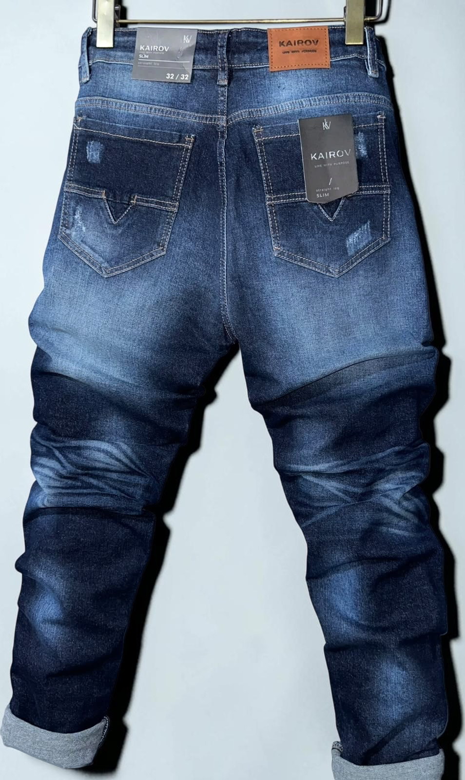 Jeans Mi tienda KAIROV de mezclilla azul slim fit con efecto deslavado, detalles desgastados y bolsillos traseros.