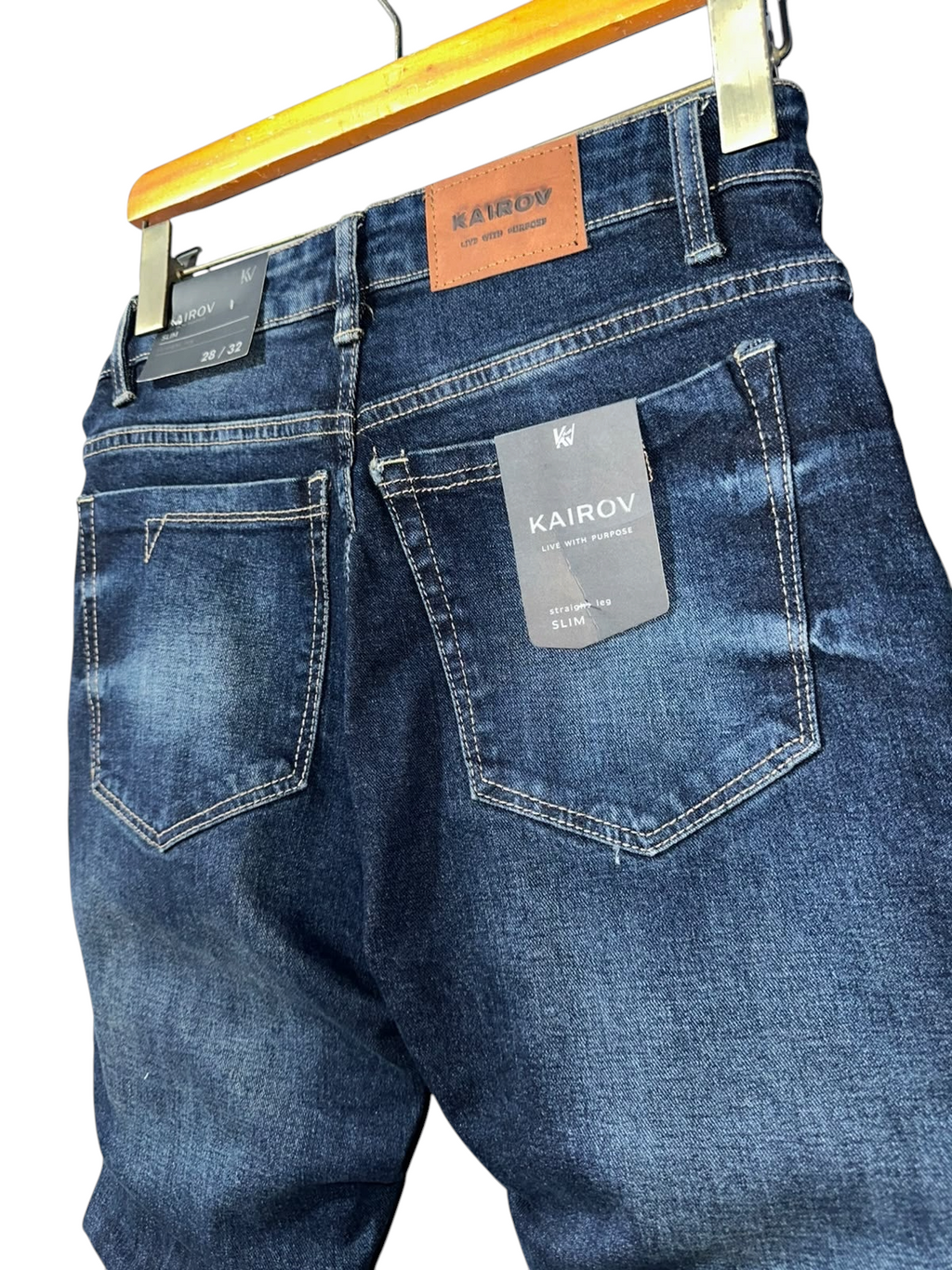 Jeans de mezclilla azul oscuro Mi tienda KAIROV con corte slim, efecto desgastado y etiqueta de cuero en la cintura.