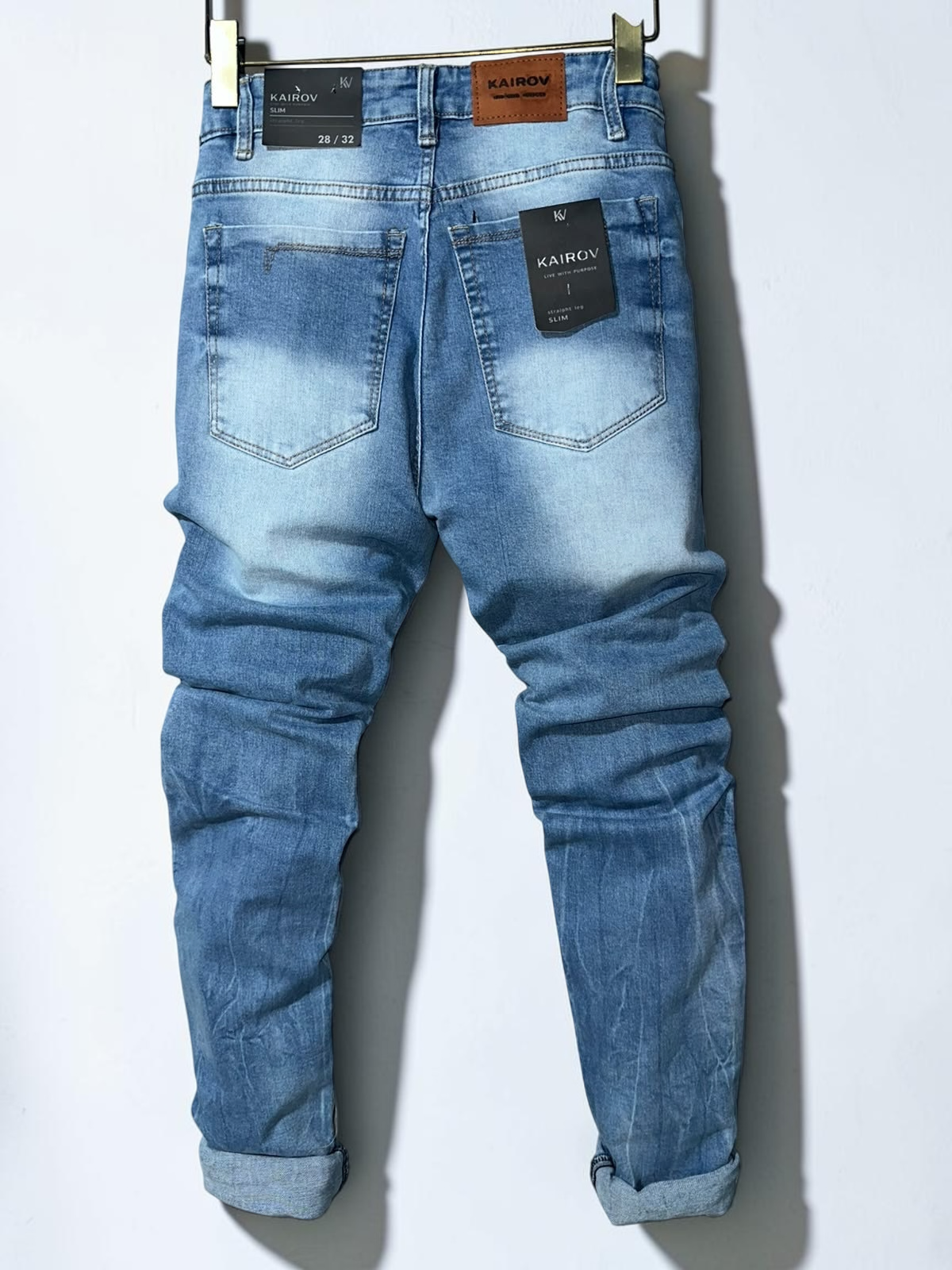 Jeans de mezclilla azul claro Mi tienda KAIROV corte slim con efecto deslavado y parche de piel en la parte trasera