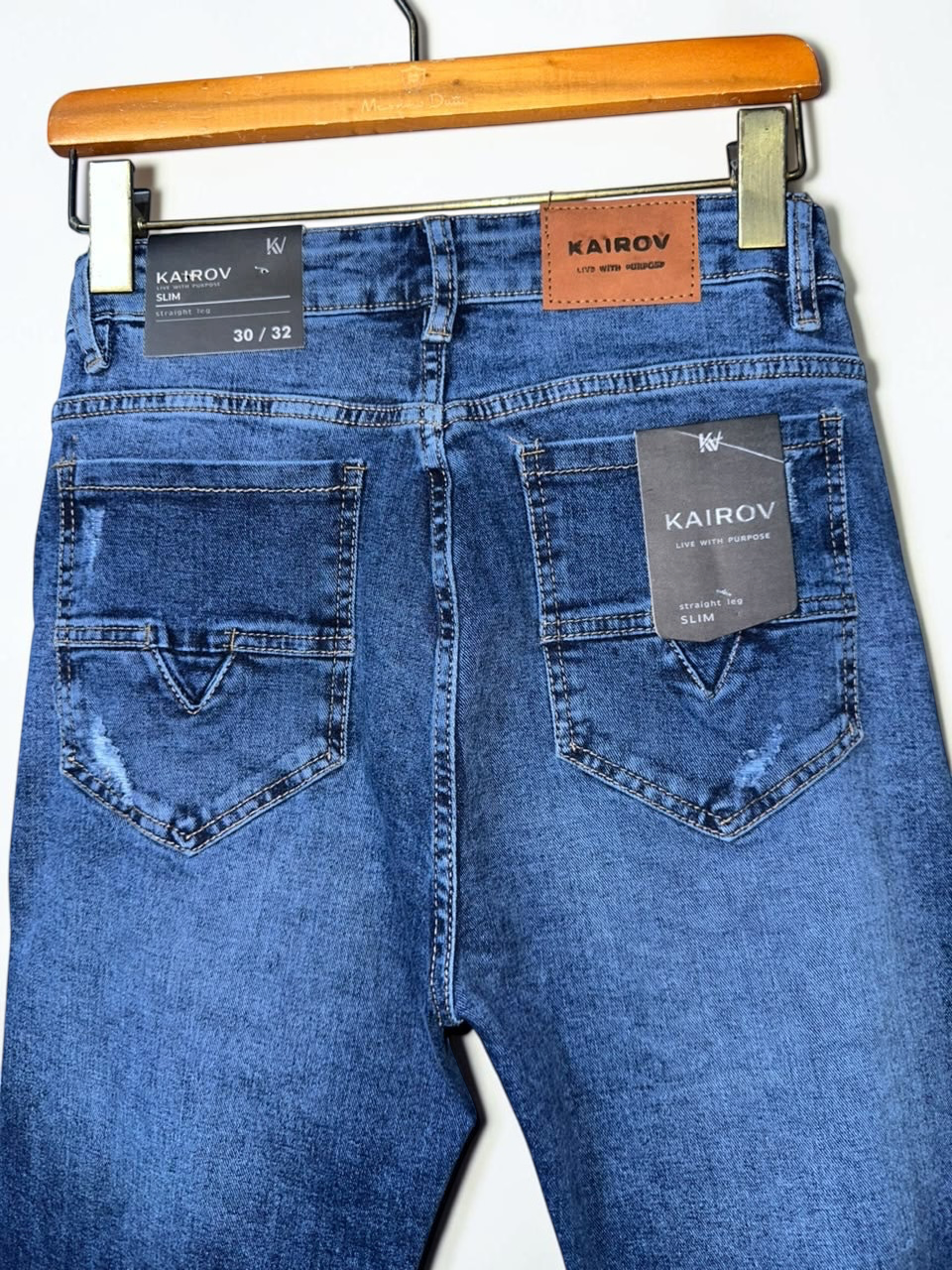 Pantalones de mezclilla Mi tienda KAIROV corte slim en azul medio con deslavado, rasgaduras y etiqueta de cuero