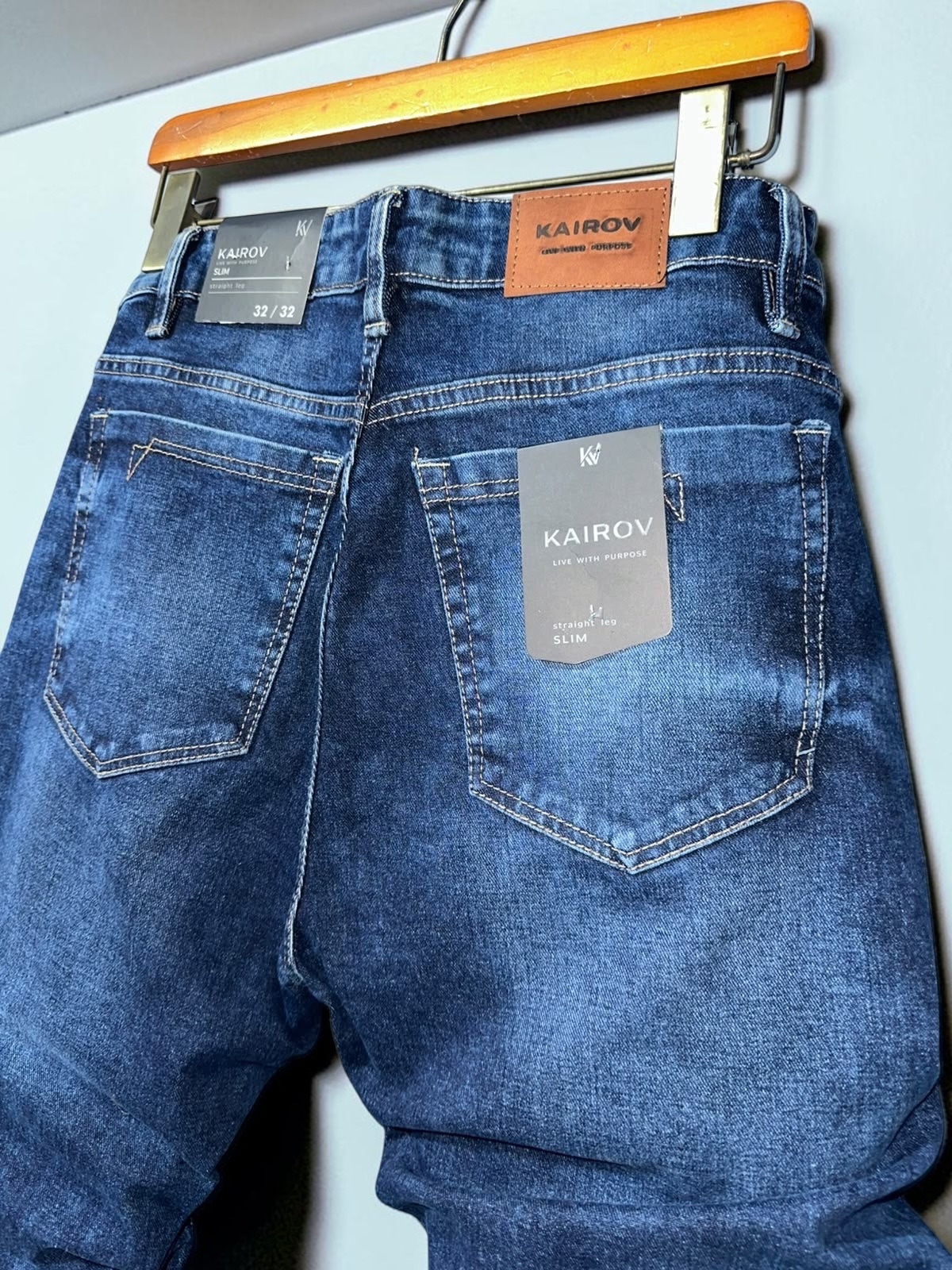 Jeans slim fit Mi tienda KAIROV en mezclilla azul con deslavado natural, etiqueta de piel y bolsillos traseros.