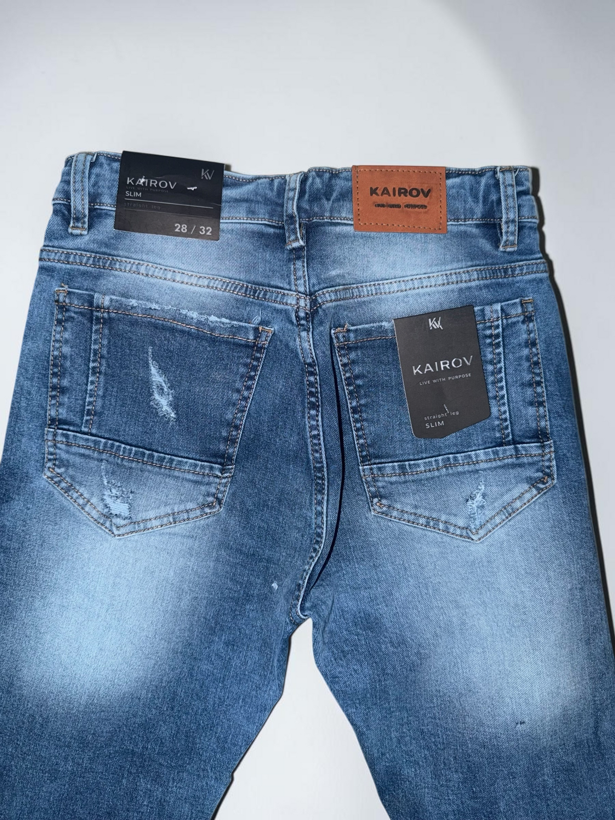 Pantalones de mezclilla Mi tienda KAIROV slim azul deslavado con detalles desgastados y parche de cuero trasero